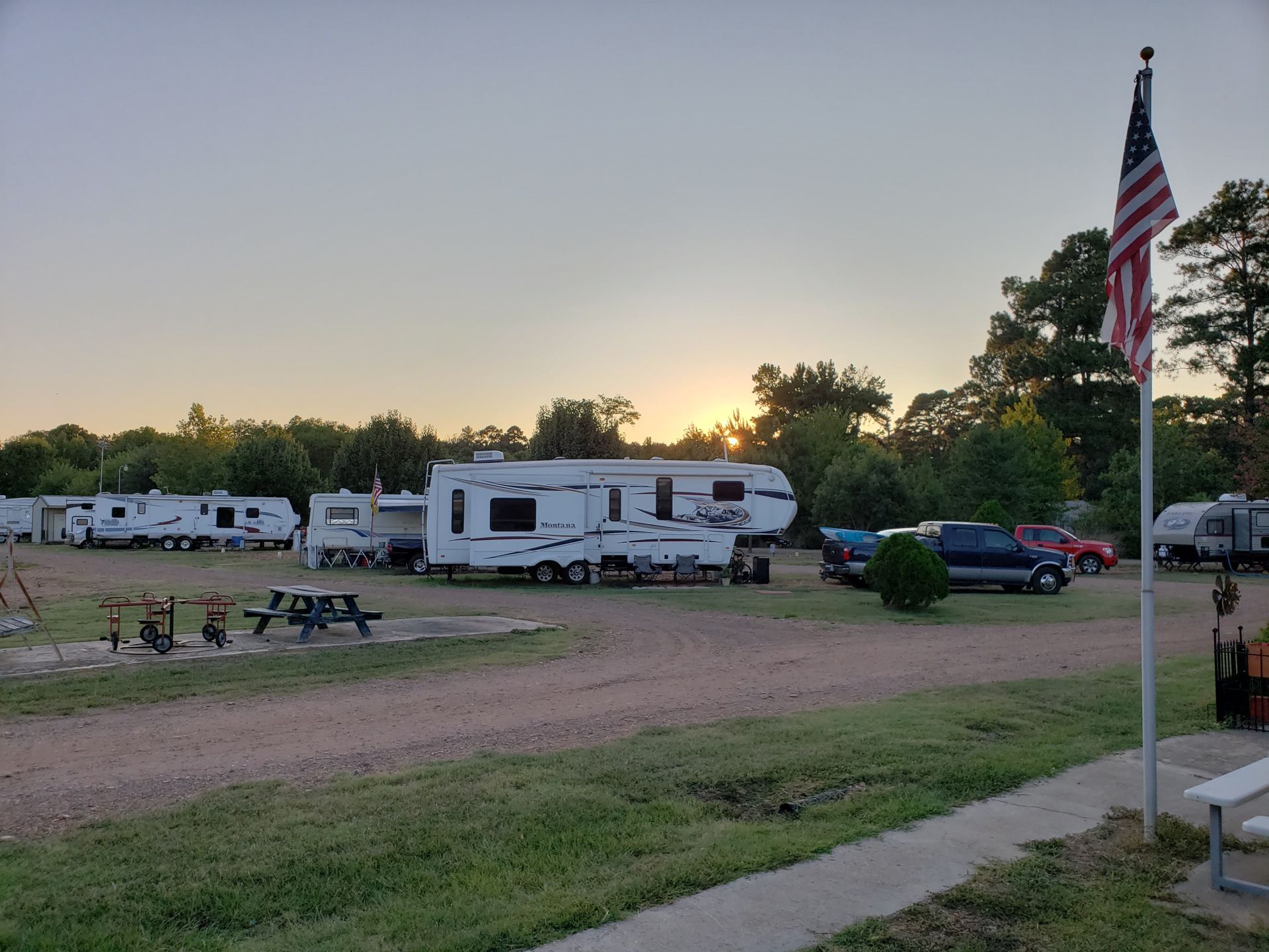 RV sites and American flag at dusk